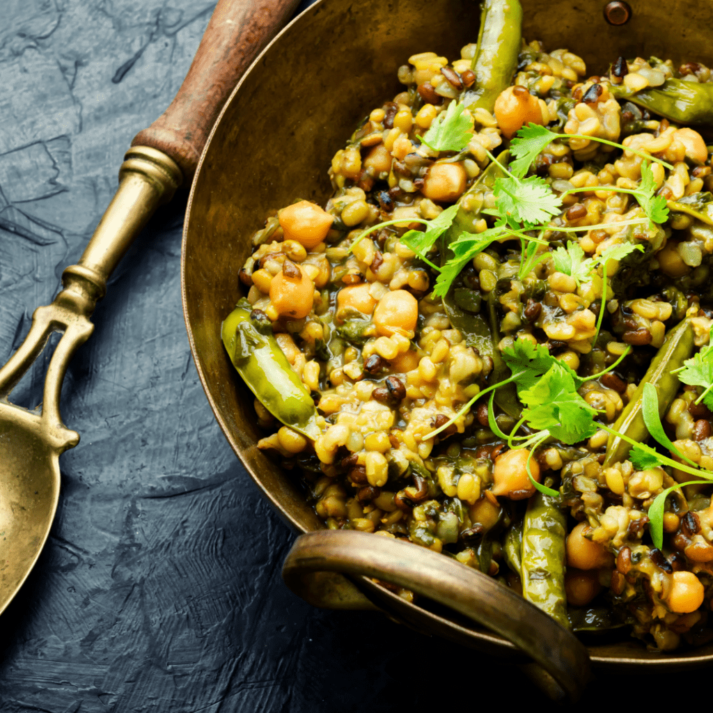 A bowl of Kitchari, a Spicy Vegetarian Dish with a golden spoon next to it.