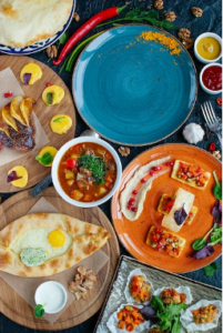 An image of a delicious Middle Eastern meal with eggs, aromatic flat breads, and flavorful vegetables.