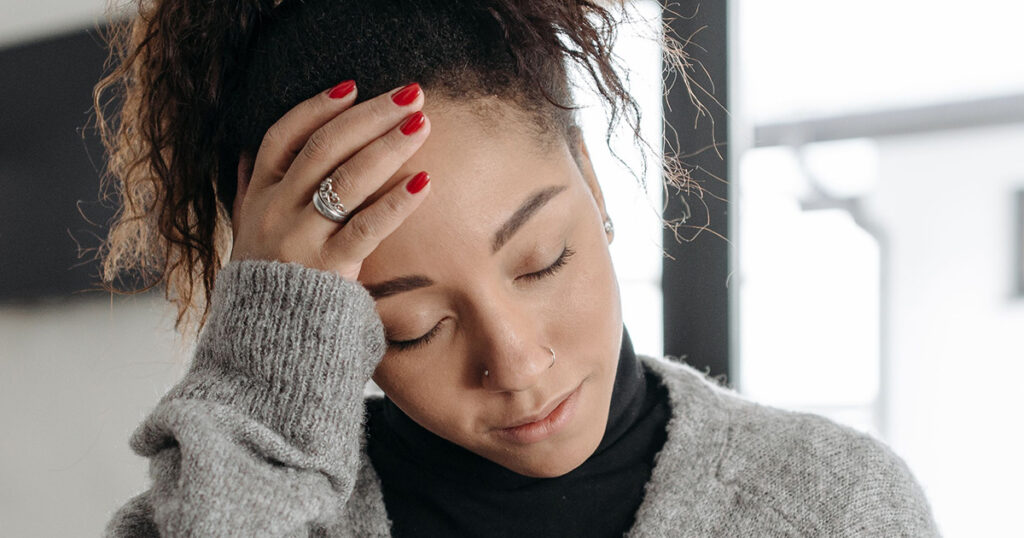 A woman holding her head due to a headache.