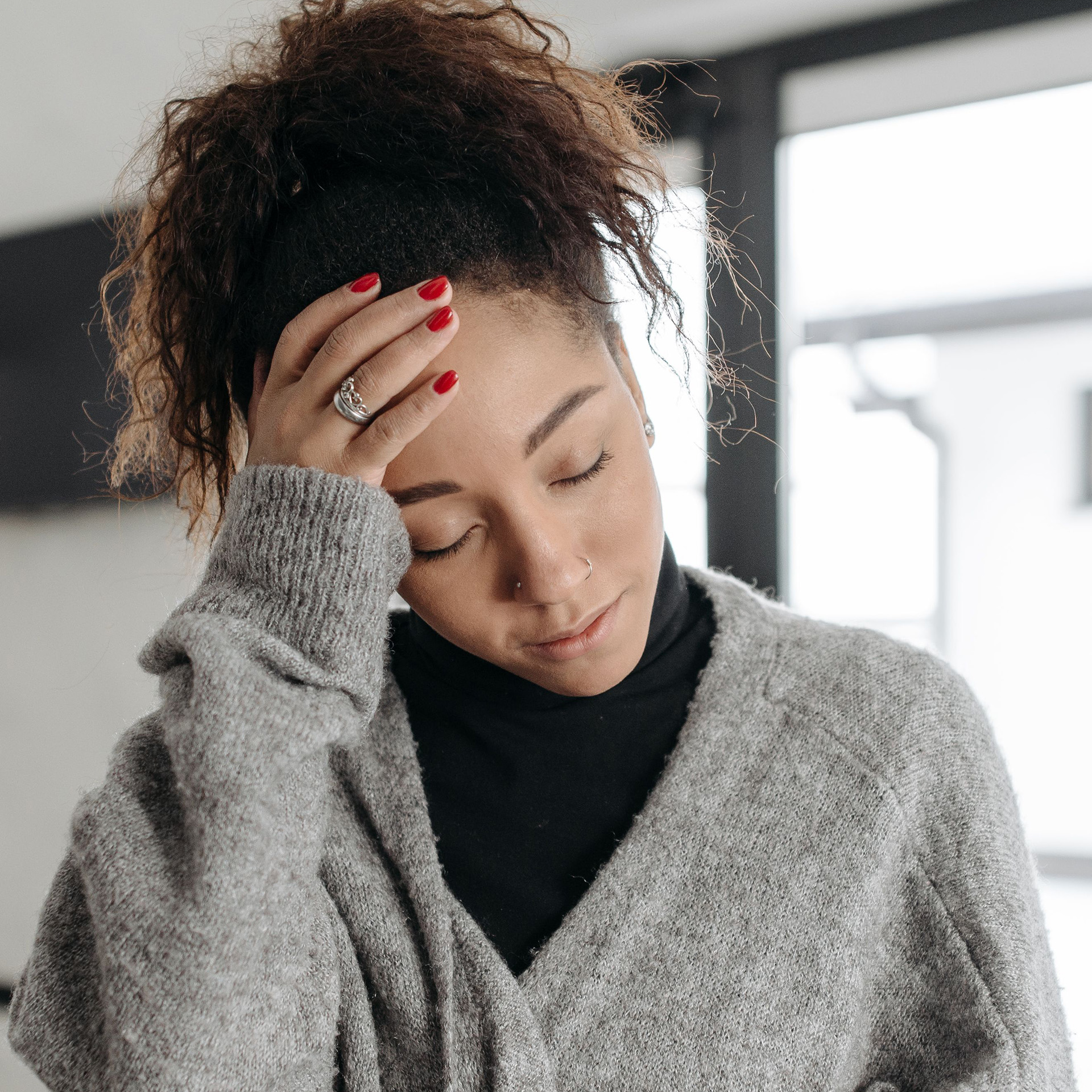 A woman holding her head due to a headache.