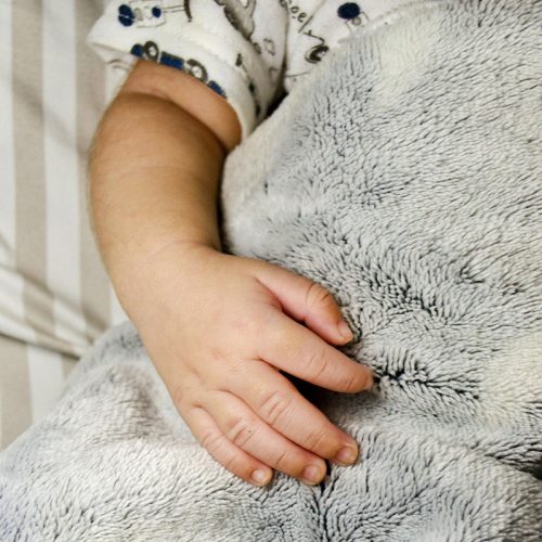 Close up of a toddler's hand on a blanket